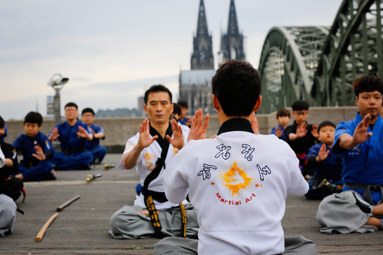 Haidong Gumdo Gruppe in Meditation vor dem Kölner Dom und der Hohenzollernbrücke